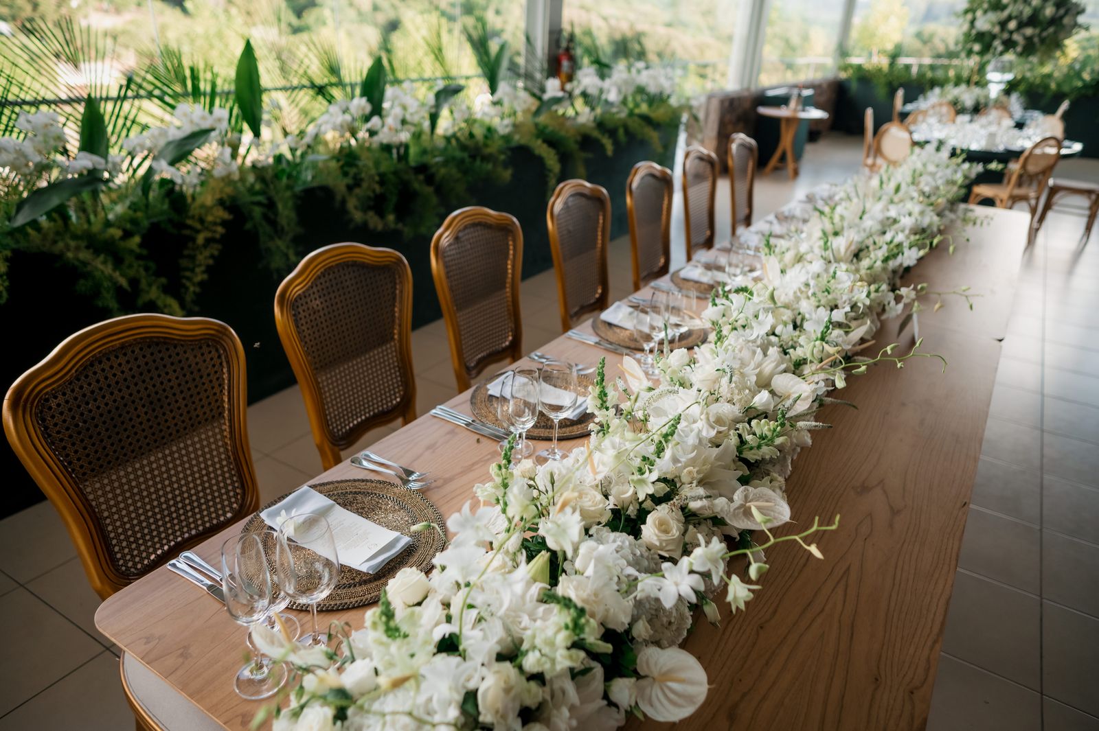 Beautifully decorated long table with white florals in an airy setting, perfect for weddings.